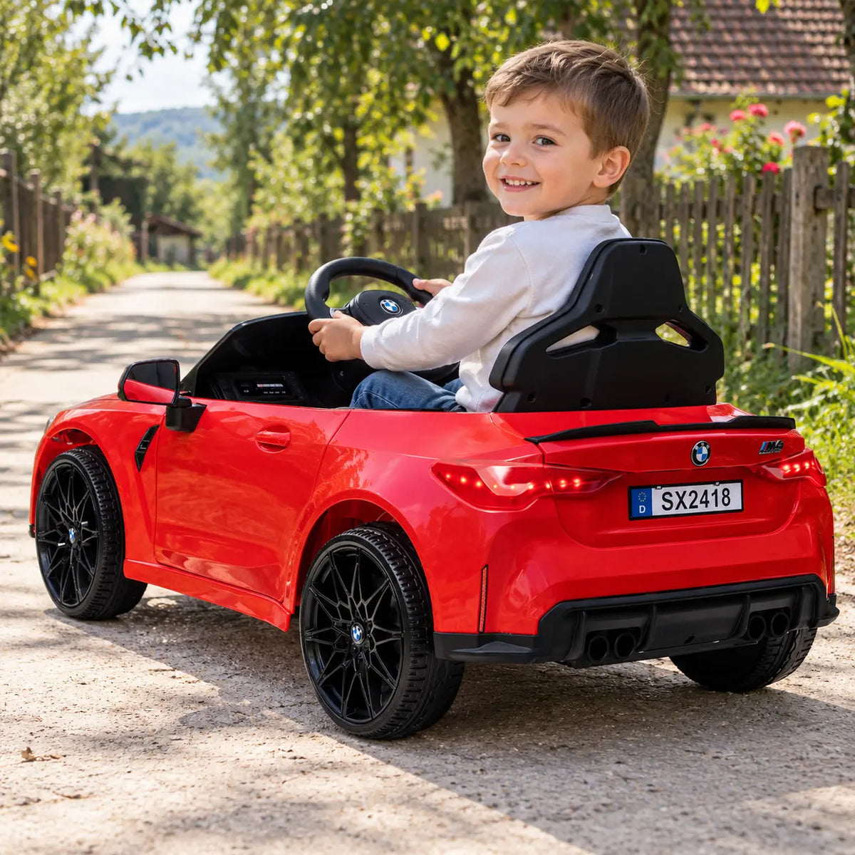 Mașinuță electrică KIDOO® BMW M4 roșie, cu un copil la volan, vedere din spate și lateral